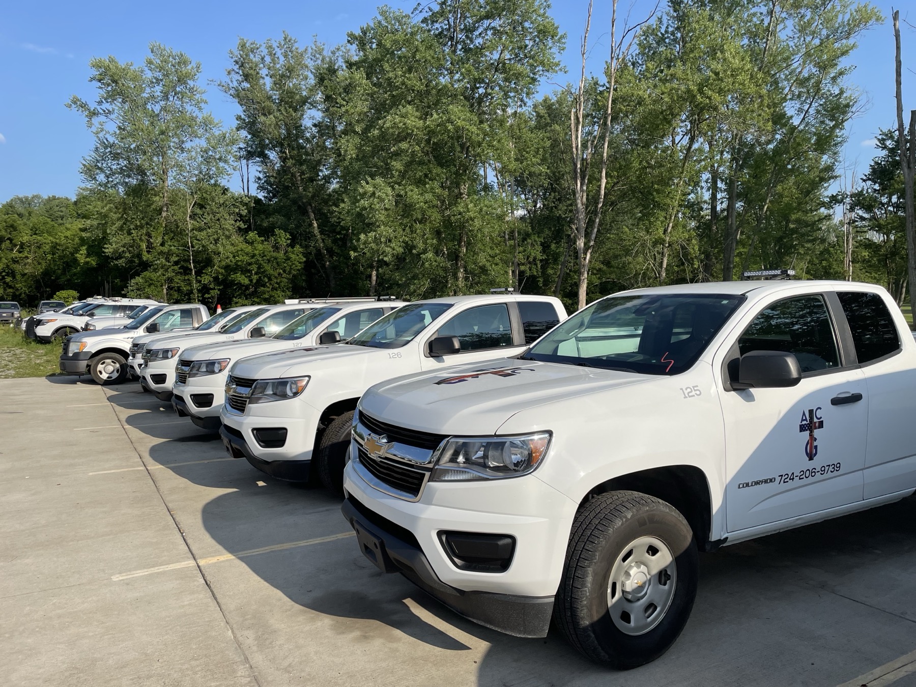A row of American Construction Group service trucks